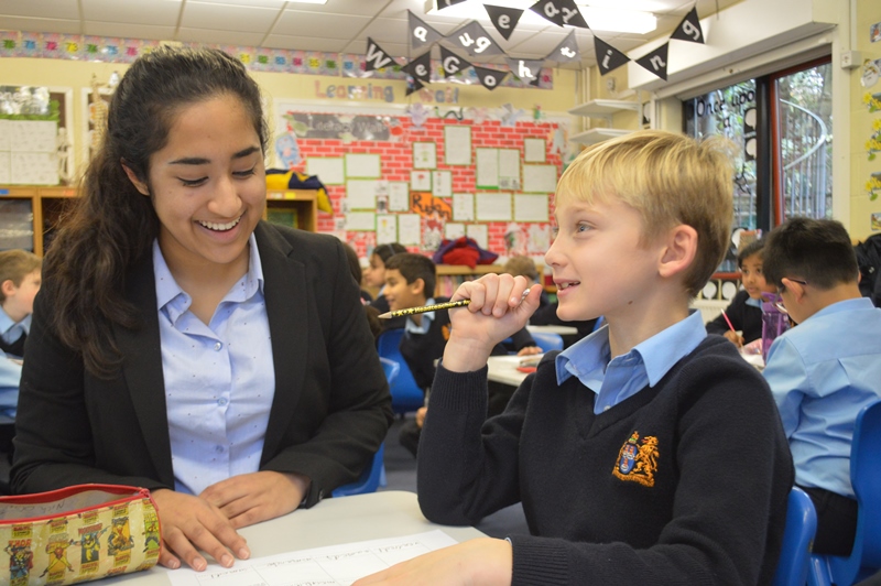 Seniro girl workign with prep boy in classroom